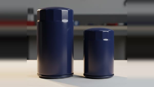 Two unbranded spin-on oil filter canisters of different sizes standing side by side on a workshop bench